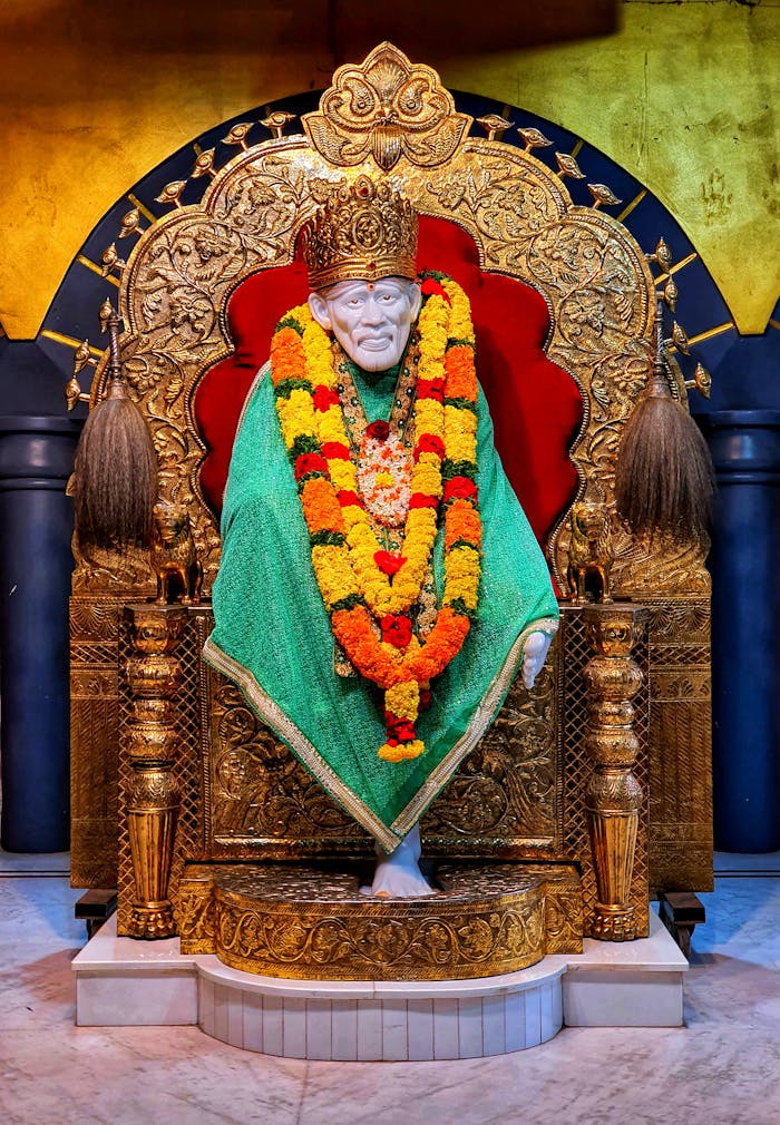A vibrant close-up of Sai Baba statue adorned with flowers and intricate decorations.